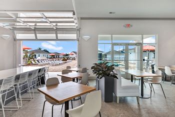 a dining area with tables and chairs and a view of the beach